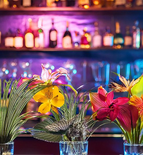 Bunte Blumen in Gläsern in einer Bar