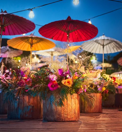 Terrasse mit farbigen Pflanzentöpfen und farbigen Sonnenschirmen